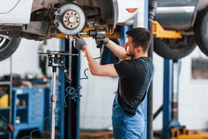 using-special-tool-man-work-uniform-repairs-white-automobile-indoors-conception-car-service